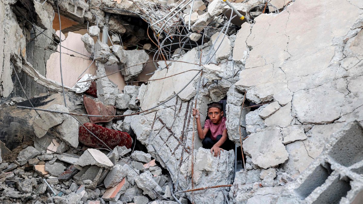 A boy climbs from out of the rubble of a collapsed building that was hit by Israeli bombardment in the Nuseirat camp for Palestinian refugees in the central Gaza Strip on Aug. 30, 2025. (AFP Photo)