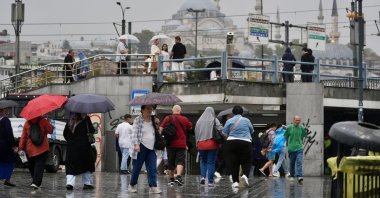 People are seen amid a rainfall in the famous Eminönü neighborhood, Istanbul, Türkiye, Sept. 6, 2025. (AA Photo)