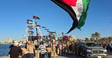 People pose for a picture in front of the Omar al-Mukhtar ship, a Libyan ship setting sail on Sept. 17 to join the Global Sumud Flotilla, at the port in Tripoli, Sept. 16, 2025. (AFP Photo)