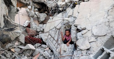 A boy climbs from out of the rubble of a collapsed building that was hit by Israeli bombardment in the Nuseirat camp for Palestinian refugees in the central Gaza Strip on Aug. 30, 2025. (AFP Photo)