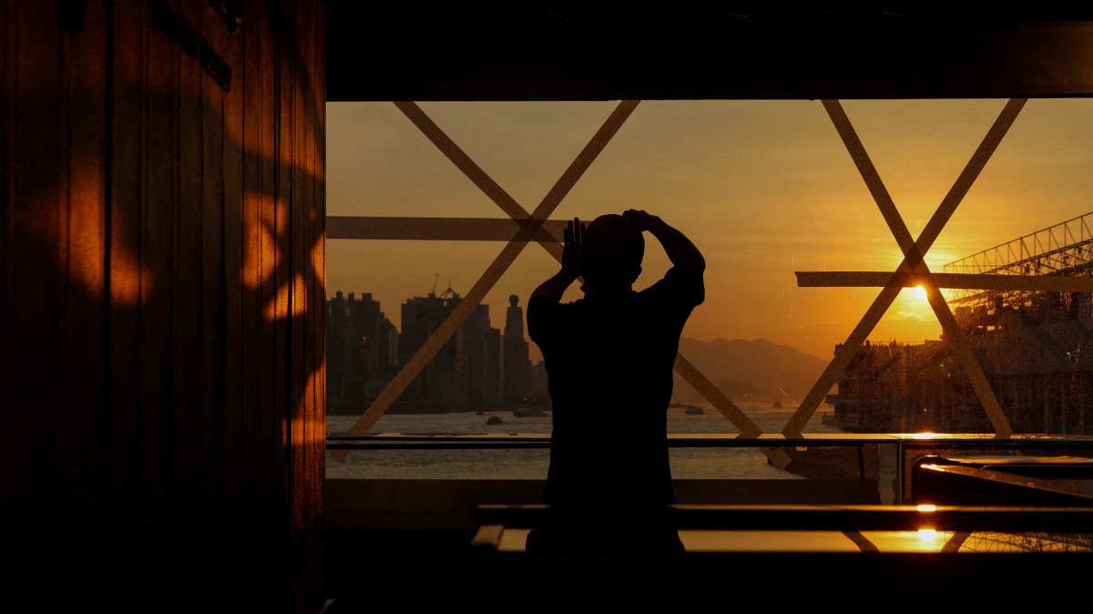 A shop worker tapes up a glass window in preparation for Typhoon Ragasa at a store in Hong Kong, China, Sept. 22, 2025. (Reuters Photo)