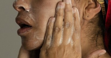 A woman washes her face as she prepares for work, Chicago, U.S., Feb. 10, 2023. (AP Photo)