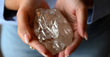 A woman holds the &quot;Motswedi&quot; a 2,488-carat rough diamond, the second largest in the world, at the HB Antwerp diamond company, Antwerp, Belgium, Sept. 22, 2025. (AFP Photo)
