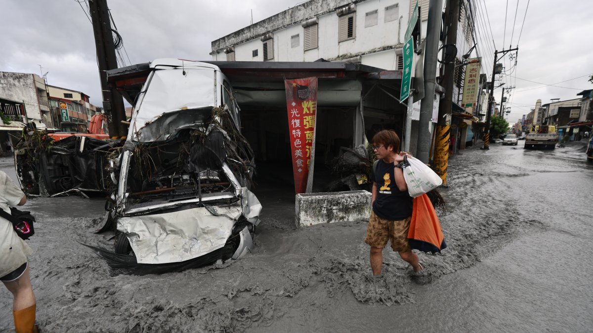 A man walks past a damaged vehicle on a flooded street in the aftermath of Super Typhoon Ragasa in Guangfu Township, Hualien County, Taiwan, Sept. 24, 2025. (EPA Photo)