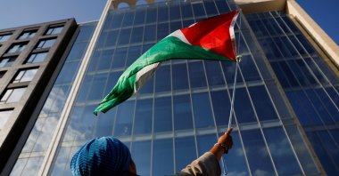 A demonstrator waves a Palestinian flag during a protest against the U.S. backing of the Israeli military operation in Gaza, outside the Washington office of the American Israel Public Affairs Committee (AIPAC), Washington, U.S., Sept. 22, 2025. (Reuters Photo)
