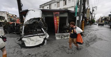 A man walks past a damaged vehicle on a flooded street in the aftermath of Super Typhoon Ragasa in Guangfu Township, Hualien County, Taiwan, Sept. 24, 2025. (EPA Photo)