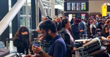 Travellers wait near check-in desks at Heathrow Airport Terminal 2, amid flight delays and cancellations, resulting from a disruption to check-in and boarding systems caused by a cyberattack which has affected several major European airports, London, Britain, Sept. 20, 2025. (Reuters Photo)