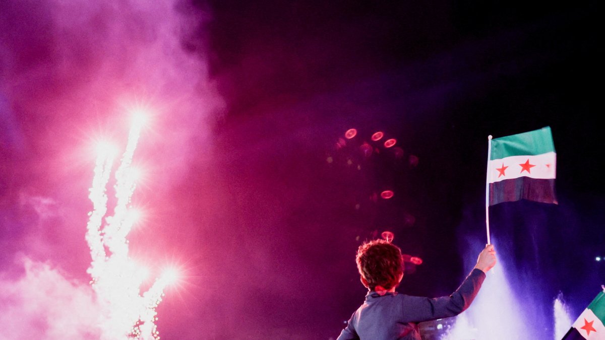 A child holds up a Syrian flag as people gather at Umayyad Square to watch a broadcast of Syrian President Ahmed Al-Sharaa&#039;s speech at the U.N., in Damascus, Syria, Sept. 24, 2025. (Reuters Photo)