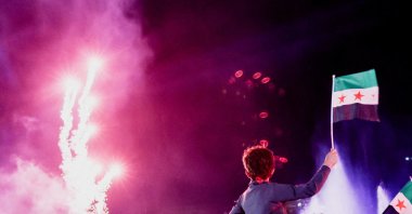 A child holds up a Syrian flag as people gather at Umayyad Square to watch a broadcast of Syrian President Ahmed Al-Sharaa&#039;s speech at the U.N., in Damascus, Syria, Sept. 24, 2025. (Reuters Photo)