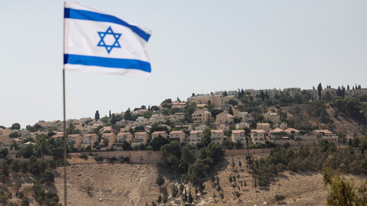 An Israeli flag flutters, as part of the Israeli settlement of Maale Adumim is visible in the background, the Israeli-occupied West Bank, Palestine, Aug. 14, 2025. (Reuters Photo)