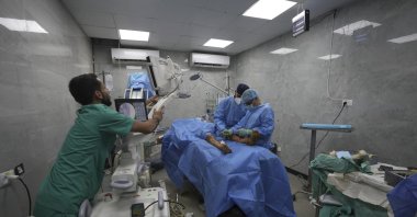 A medical team performs surgery on a patient with a foot injury caused by an Israeli strike, in an operating room with unstable electricity at Shifa Hospital, Gaza City, Palestine, July 4, 2025. (AP Photo)