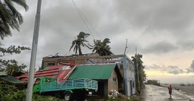 A resident walking past a building with a ripped roof destroyed at the height of Severe Tropical Storm (STS) Bualoi, Masbate City, Bicol region, Manila, Philippines, Sept. 26, 2025. (AFP Photo)