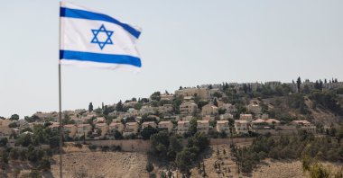 An Israeli flag flutters, as part of the Israeli settlement of Maale Adumim is visible in the background, the Israeli-occupied West Bank, Palestine, Aug. 14, 2025. (Reuters Photo)