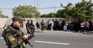 Security forces stand guard as Palestinians wait near the Allenby Bridge Crossing in the Israeli-occupied West Bank to travel to Jordan, Friday, Sept. 26, 2025. (Reuters Photo)