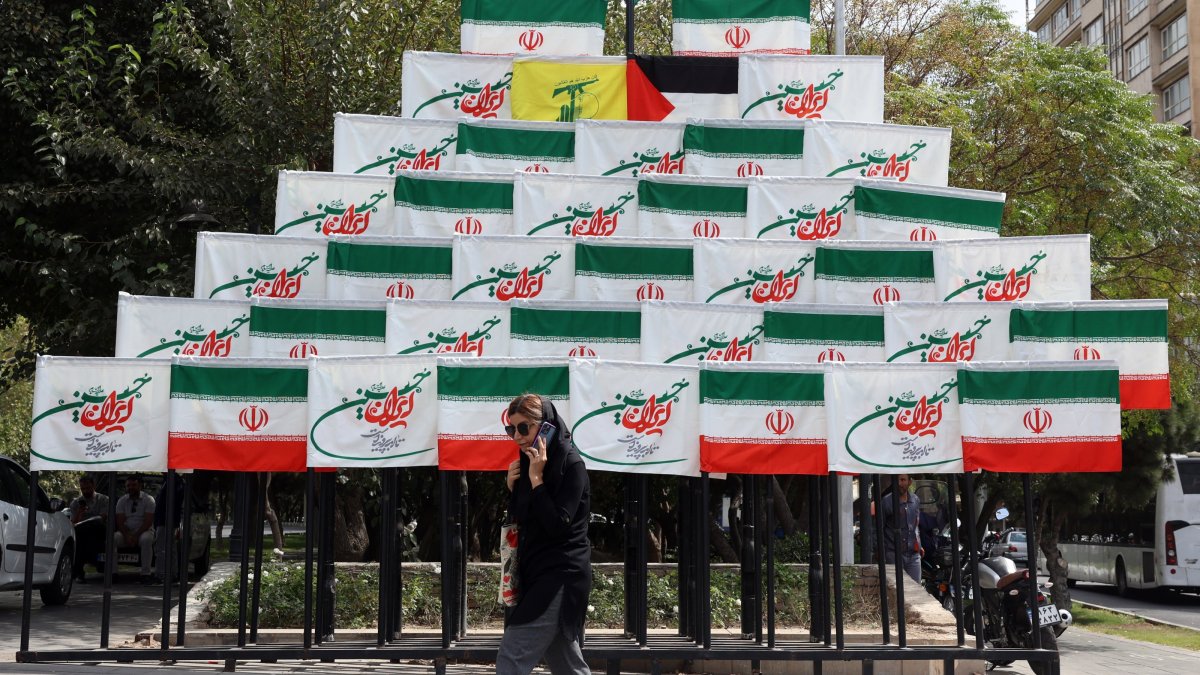 A woman walks past Iran&#039;s national flags in Tehran, Iran, Sept. 27, 2025. (EPA Photo)