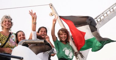 Greta Thunberg and a crew members flash victory signs from their ship, part of the Global Sumud Flotilla aiming to reach Gaza and break Israel&#039;s naval blockade, as they sail off Crete island, Greece, Sept. 25, 2025. (Reuters Photo)