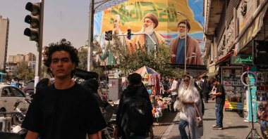 People walk in front of a billboard depicting slain Lebanese Hezbollah leaders Hassan Nasrallah (C) and his successor Hashem Safieddine (R) as well as the late Iranian General Qasem Soleimani, in Tehran, Iran, Sept. 28, 2025. (AFP Photo)