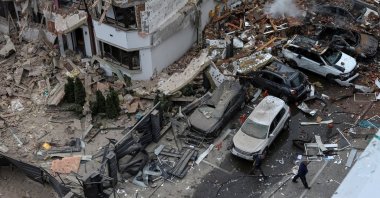 People walk next to a damaged building and vehicles hit during a Russian drone and missile strike, Kyiv, Ukraine, Sept. 28, 2025. (Reuters Photo)