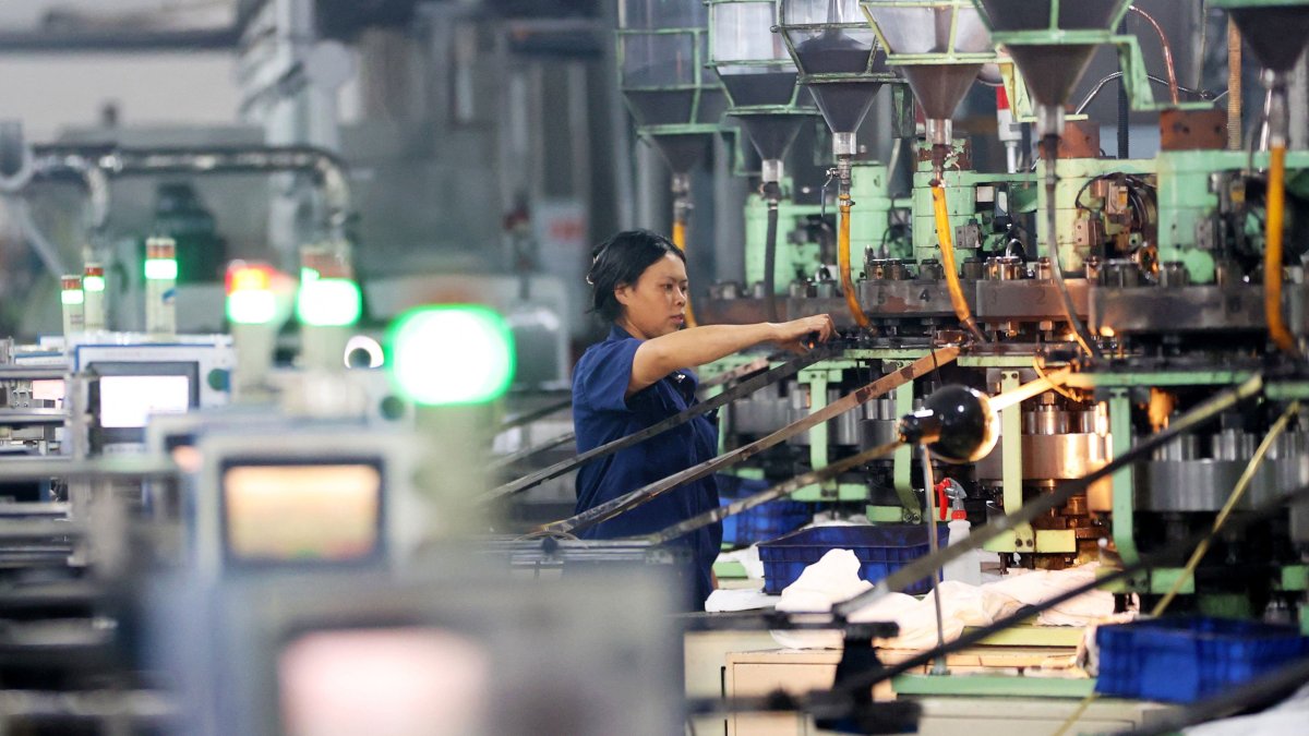 A woman works at an electronics factory in Chongqing, southwest China, Sept. 13, 2025. (AFP Photo)