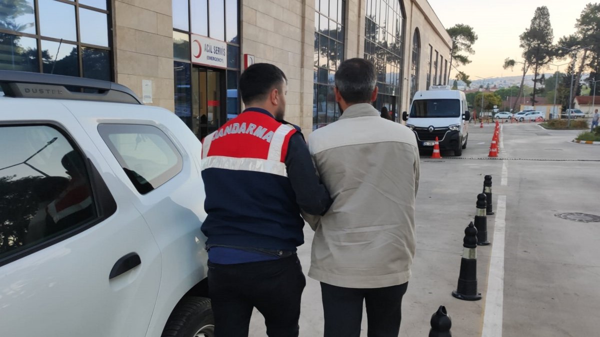 Gendarmerie officer escorts a FETÖ suspect, Izmir, Türkiye, Sept. 30, 2025. (AA Photo)