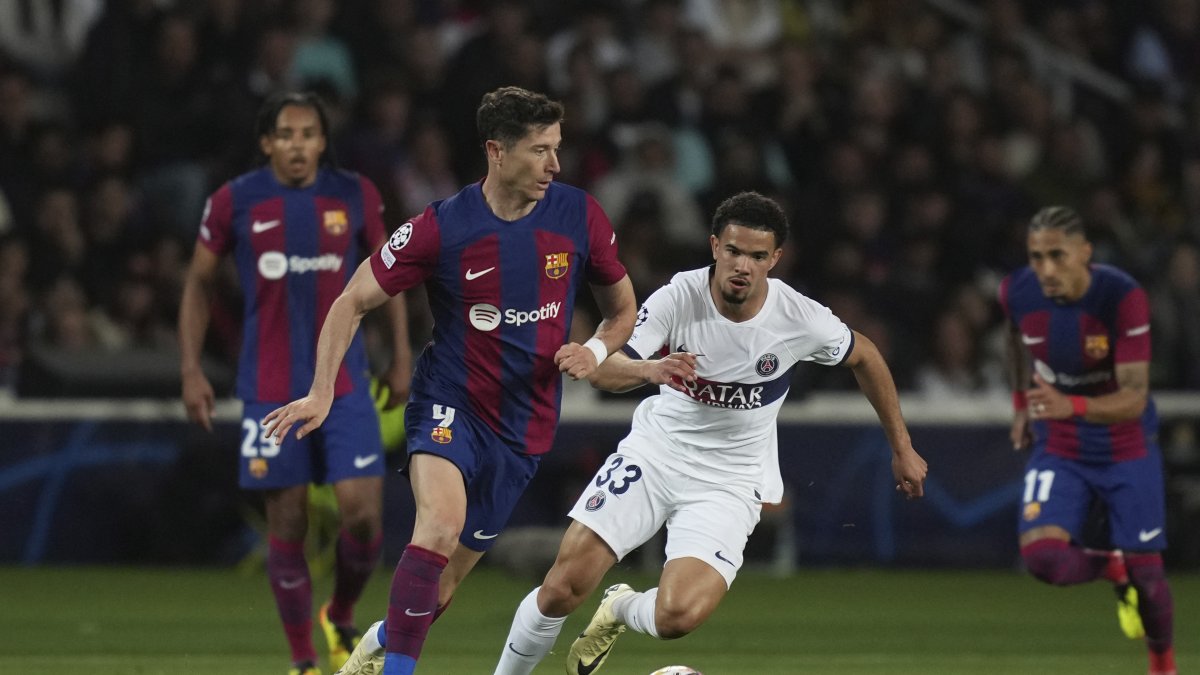 Barcelona&#039;s Robert Lewandowski (L) runs with the ball past PSG&#039;s Warren Zaire-Emery during the Champions League quarterfinal second leg match at the Olimpic Lluis Companys stadium, Barcelona, Spain, April 16, 2024. (AP Photo)