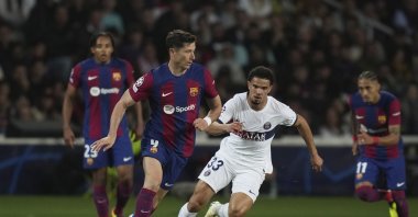 Barcelona&#039;s Robert Lewandowski (L) runs with the ball past PSG&#039;s Warren Zaire-Emery during the Champions League quarterfinal second leg match at the Olimpic Lluis Companys stadium, Barcelona, Spain, April 16, 2024. (AP Photo)