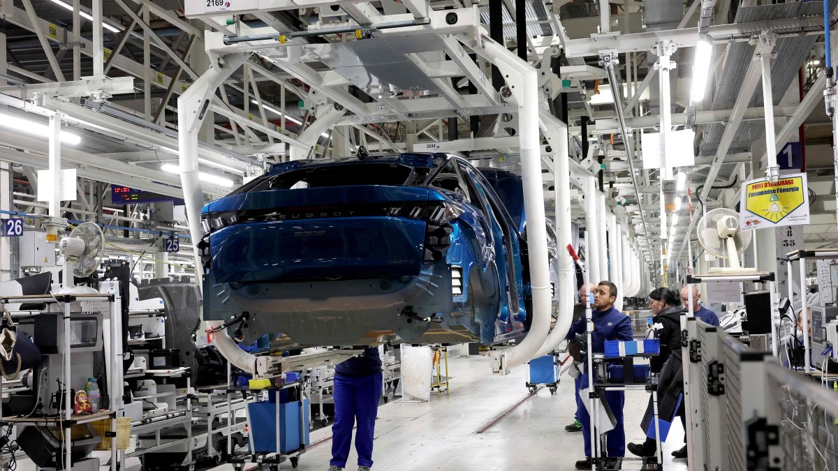 Employees are at work on the production line of the new Peugeot e-3008 and e-5008 electric car at the Stellantis factory, Sochaux, France, Oct. 3, 2024. (AFP Photo)