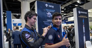 Turkish astronaut Tuva Cihangir Atasever signs a young attendee’s shirt during the Turkish pavilion session at IAC 2025, Sydney, Australia, Sept. 30, 2025. (AA Photo)