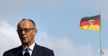German Chancellor Friedrich Merz speaks next to a German flag during a press conference at the Foreign Ministry, Berlin, Germany, Oct. 1, 2025. (AFP Photo)