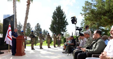 Flanked by troops, Defense Ministry spokesperson Zeki Aktürk speaks at a news conference, Girne (Kyrenia), TRNC, Oct. 2, 2025. (AA Photo)