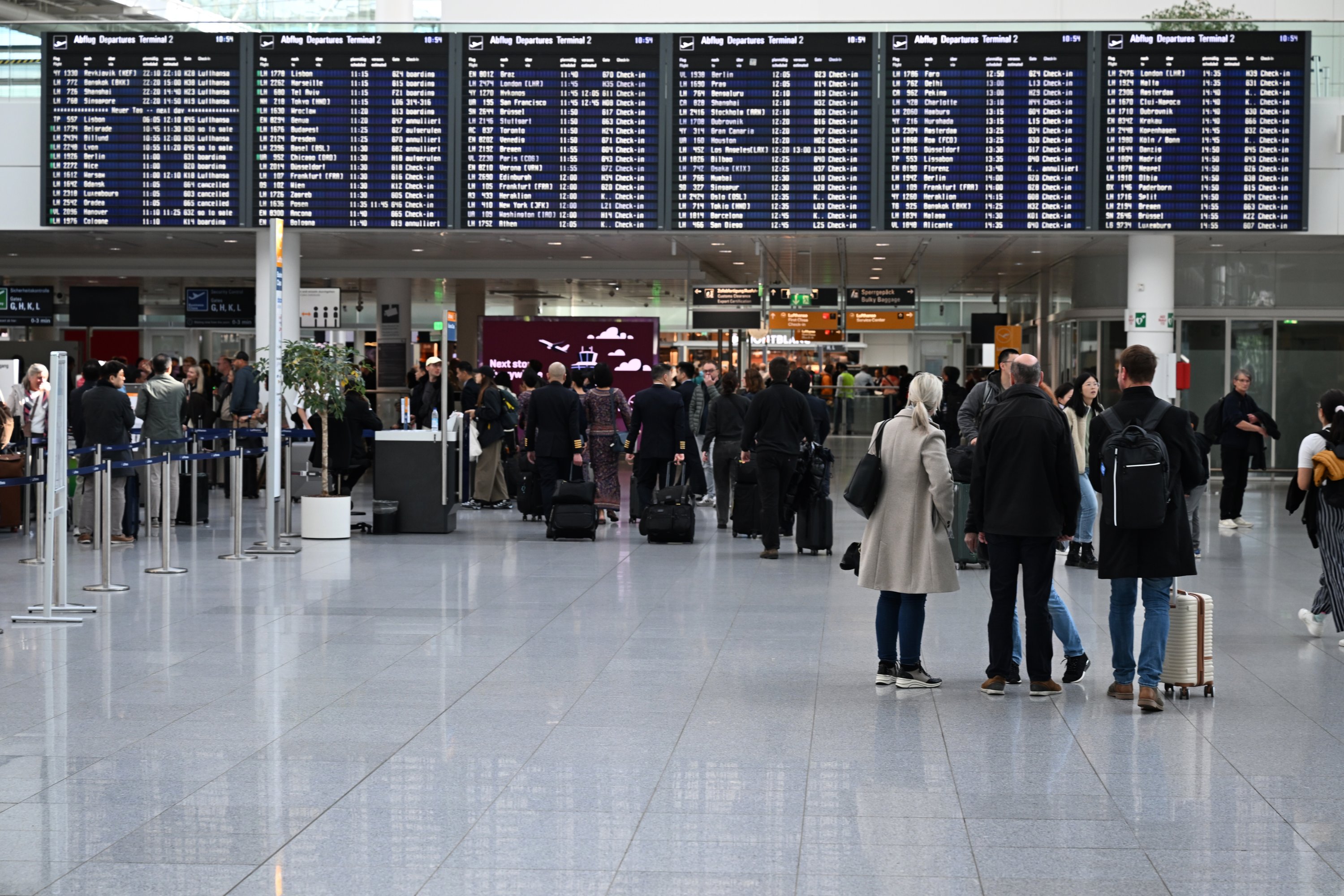 Los pasajeros se paran frente a un tablero de anuncios en la Terminal 2 del aeropuerto de Munich, Munich, Alemania, el 3 de octubre de 2025. (Foto AP)