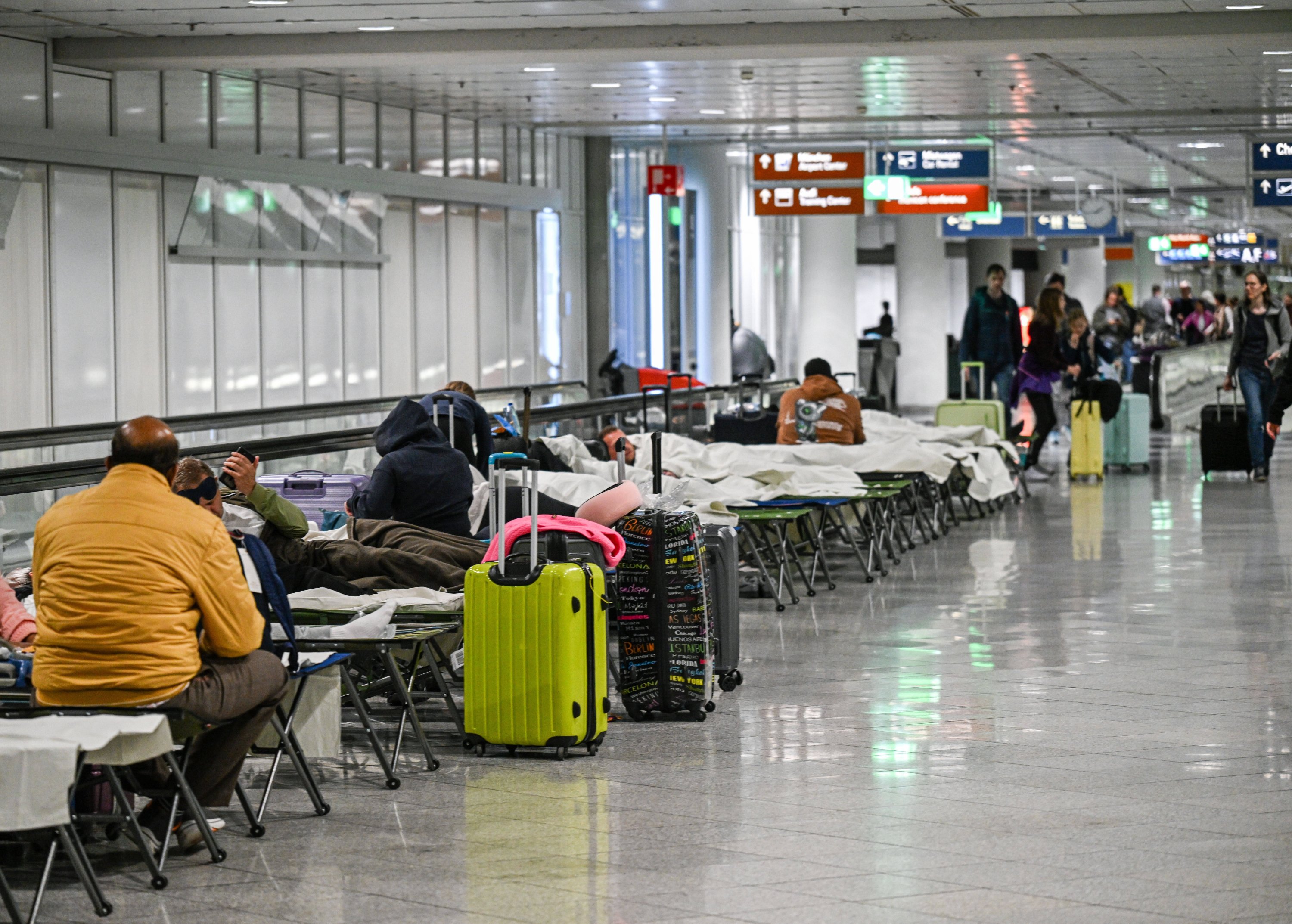 La gente espera en catres después de avistamientos de drones y cancelaciones de vuelos en el aeropuerto de Munich, Munich, Alemania, el 3 de octubre de 2025. (Foto AP)