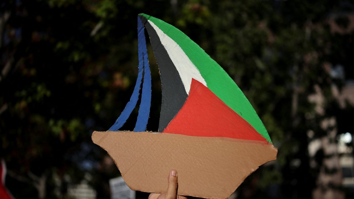 A Pro-Palestinian demonstrator holds a sign depicting a vessel of the Global Sumud Flotilla aiming to reach Gaza and break Israel's naval blockade during a protest to condemn the Israeli forces' interception of some of vessels of the Global Sumud Flotilla aiming to reach Gaza and break Israel's naval blockade, outside the Consulate General of Israel in Los Angeles, California, U.S., Oct. 2, 2025. (Reuters Photo)