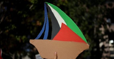A Pro-Palestinian demonstrator holds a sign depicting a vessel of the Global Sumud Flotilla aiming to reach Gaza and break Israel's naval blockade during a protest to condemn the Israeli forces' interception of some of vessels of the Global Sumud Flotilla aiming to reach Gaza and break Israel's naval blockade, outside the Consulate General of Israel in Los Angeles, California, U.S., Oct. 2, 2025. (Reuters Photo)