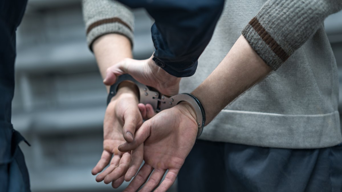 A suspect’s hands are secured in handcuffs during an operation. (Shutterstock Photo)