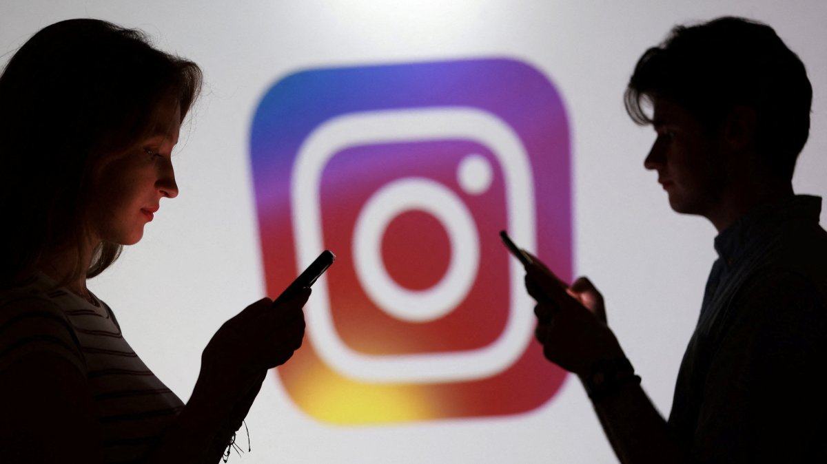 Teenagers pose for a photo while holding smartphones in front of an Instagram logo in this illustration taken Sept. 11, 2025. (Reuters Photo)