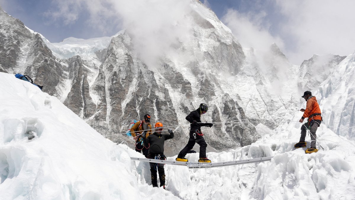 Mountaineers practice walking on a ladder during a training session at Everest base camp, Nepal, April 15, 2025. (Reuters Photo)