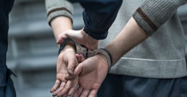 A suspect’s hands are secured in handcuffs during an operation. (Shutterstock Photo)