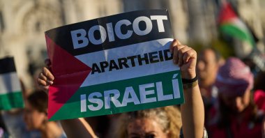 A pro-Palestinian demonstrator holds a banner reading: &quot;Boycott Israeli apartheid&quot; during a protest in Madrid, Spain, Oct. 4, 2025. (AP Photo)