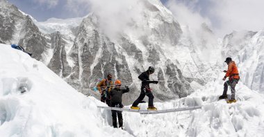 Mountaineers practice walking on a ladder during a training session at Everest base camp, Nepal, April 15, 2025. (Reuters Photo)