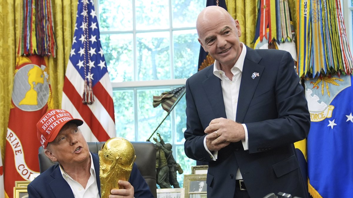 President Donald Trump holds the FIFA World Cup Winners Trophy as FIFA President Gianni Infantino looks on during an announcement in the Oval Office of the White House, Washington, U.S., Aug. 22, 2025. (AP Photo)