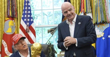 President Donald Trump holds the FIFA World Cup Winners Trophy as FIFA President Gianni Infantino looks on during an announcement in the Oval Office of the White House, Washington, U.S., Aug. 22, 2025. (AP Photo)