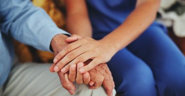 A nurse provides personal care to an elderly citizen at home. (Shutterstock Photo)