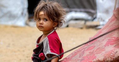 A girl sits outside one of the tents sheltering people displaced by war in Khan Yunis, southern Gaza Strip, Palestine, Oct. 6, 2025. (AFP Photo)