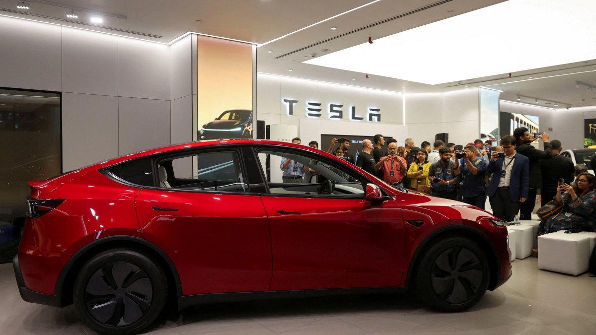 Media personnel take pictures and videos of the Tesla Model Y car at India&#039;s first Tesla showroom in Mumbai, India, July 15, 2025. (Reuters Photo)