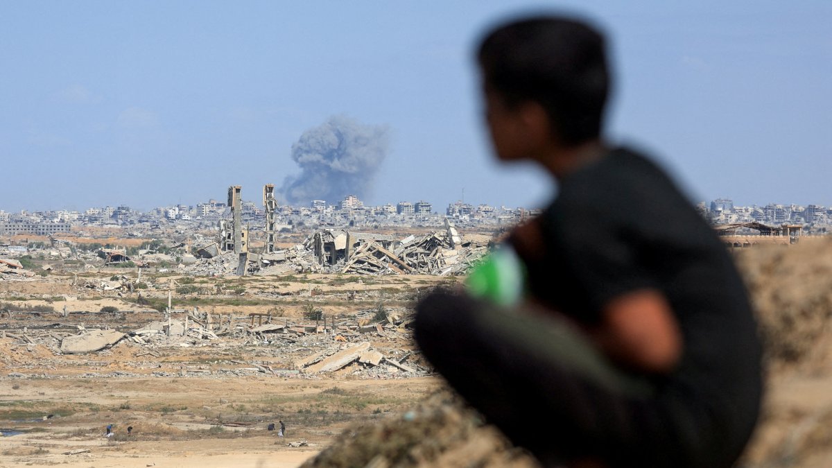 A Palestinian child sits in front of the scene of rising smoke following explosions amid the Israeli offensive, Gaza City, central Gaza Strip, Palestine, Oct. 6, 2025. (Reuters Photo)