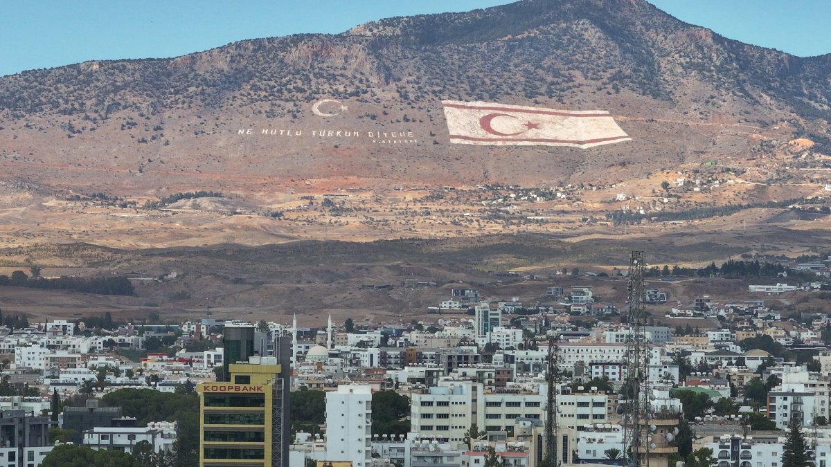 A flag of the Turkish Republic of Northern Cyprus (TRNC) and the motto of Mustafa Kemal Atatürk, &quot;Ne mutlu Türküm diyene&quot; (&quot;Happy is he who calls himself a Turk&quot;), are seen on the slopes of the Beşparmak Mountains overlooking Lefkoşa (Nicosia), TRNC, Oct. 5, 2024. (AA Photo)