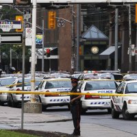 A police officer stands in front of police cars at the Toronto Eaton Centre shopping mall in Toronto, Canada, June 2, 2012. (Reuters File Photo)
