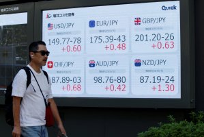 A man walks in front of a screen displaying exchange rates between yen and other currencies outside a brokerage in Tokyo, Japan, Oct. 6, 2025. (Reuters Photo)
