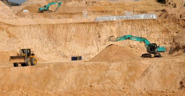 Workers use machinery to dig at a rare earth mine in the Ganxian county, Jiangxi, central China, Dec. 30, 2010. (AP Photo)